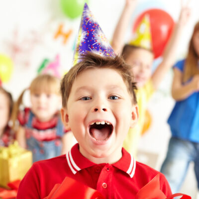 Joyful,Boy,Looking,At,Camera,With,His,Friends,On,Background